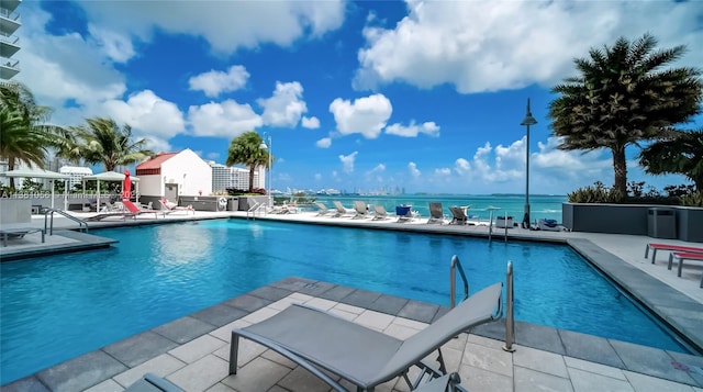 view of pool with a water view and a patio area