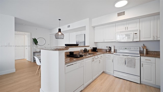 kitchen featuring pendant lighting, white appliances, white cabinetry, and light hardwood / wood-style flooring