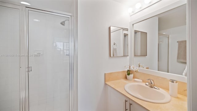 bathroom with walk in shower and vanity with extensive cabinet space