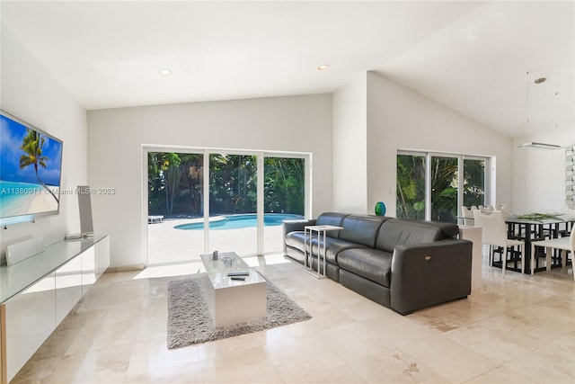 living room with plenty of natural light and high vaulted ceiling