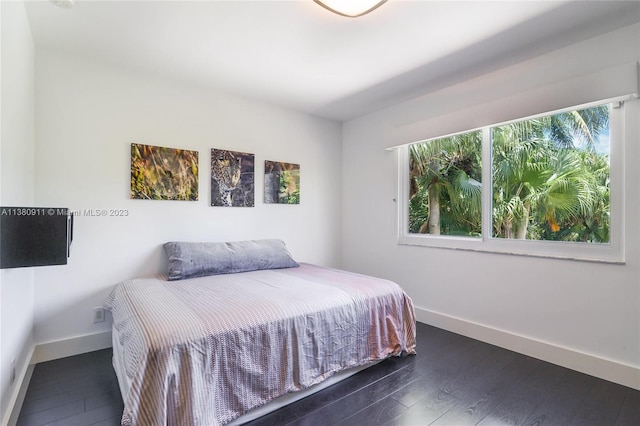 bedroom with dark hardwood / wood-style floors