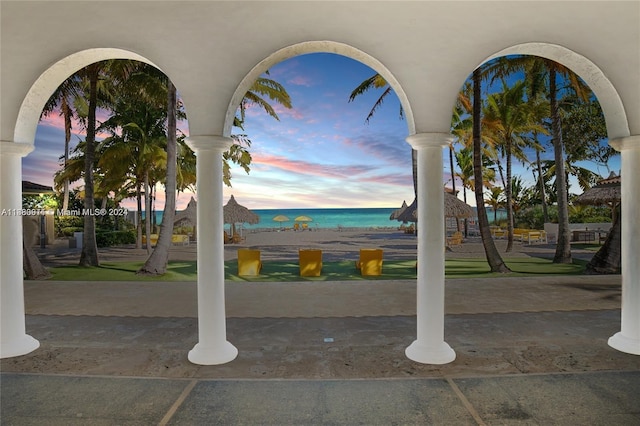 patio terrace at dusk featuring a water view