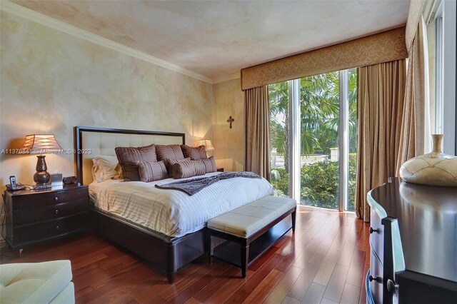 bedroom featuring dark hardwood / wood-style floors, ornamental molding, and multiple windows