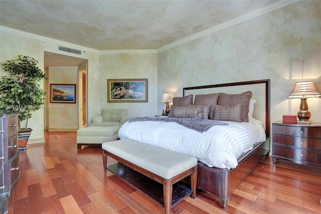 bedroom featuring crown molding and wood-type flooring