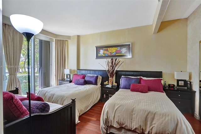 bedroom with dark hardwood / wood-style floors and multiple windows