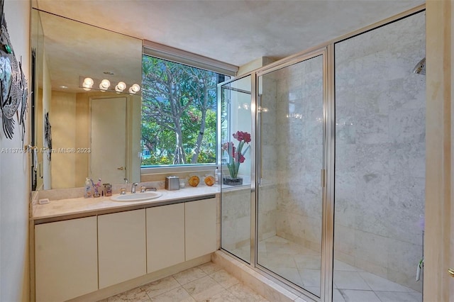 bathroom featuring large vanity, a shower with door, and tile flooring