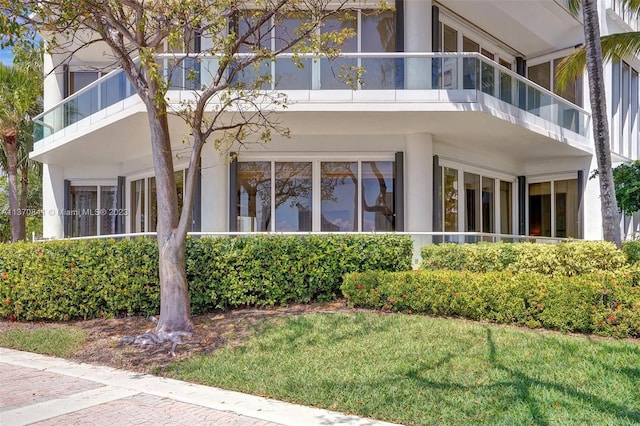 exterior space featuring a balcony and a lawn