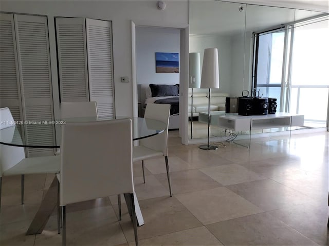 dining space with expansive windows and light tile floors