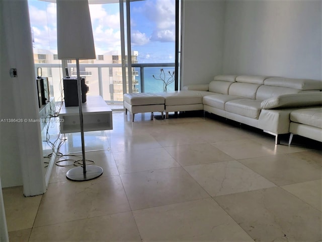 living room with plenty of natural light, floor to ceiling windows, and light tile floors