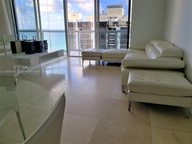 tiled living room with expansive windows and a water view