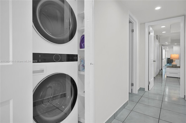 laundry area featuring light tile patterned floors, recessed lighting, laundry area, baseboards, and stacked washer / drying machine