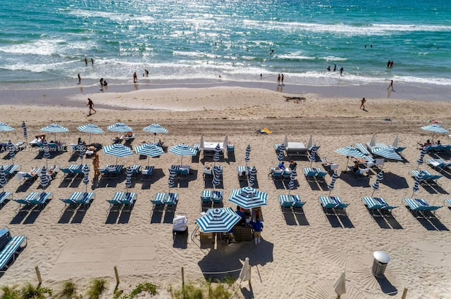 drone / aerial view featuring a water view and a view of the beach