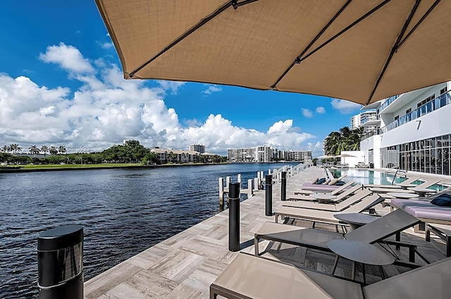 dock area with a water view and a community pool