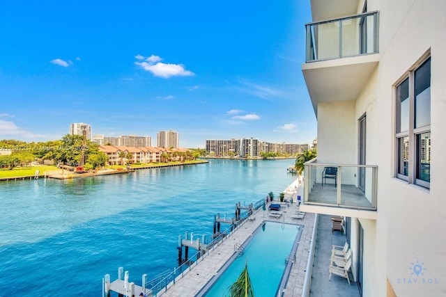 balcony with a community pool and a water view