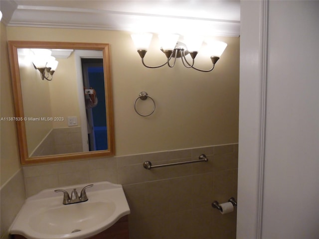 bathroom with sink, ornamental molding, and tile walls