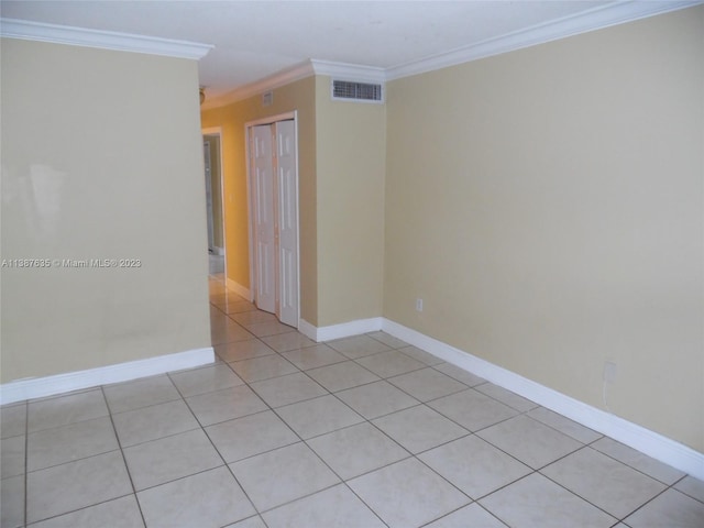 unfurnished room featuring ornamental molding and light tile flooring