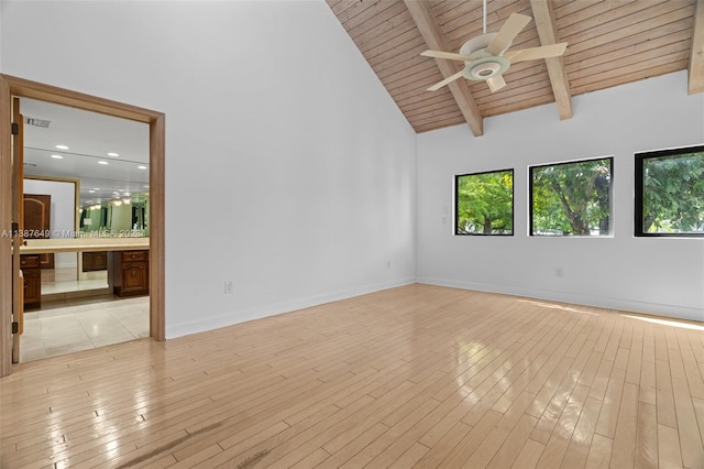 empty room with light wood-type flooring, wood ceiling, ceiling fan, and beamed ceiling