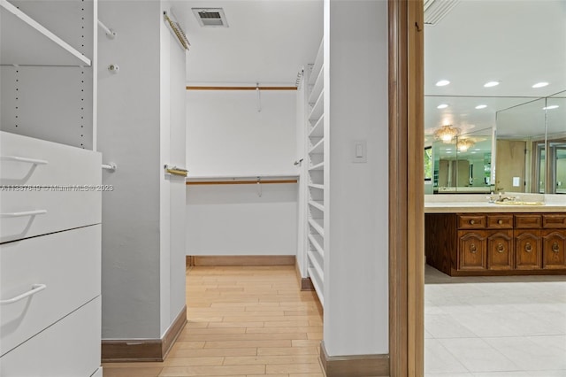 walk in closet featuring light hardwood / wood-style floors and sink