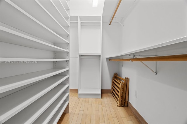 spacious closet with light hardwood / wood-style flooring