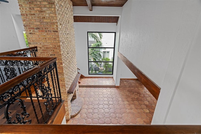 stairway with wooden ceiling, tile flooring, and beam ceiling