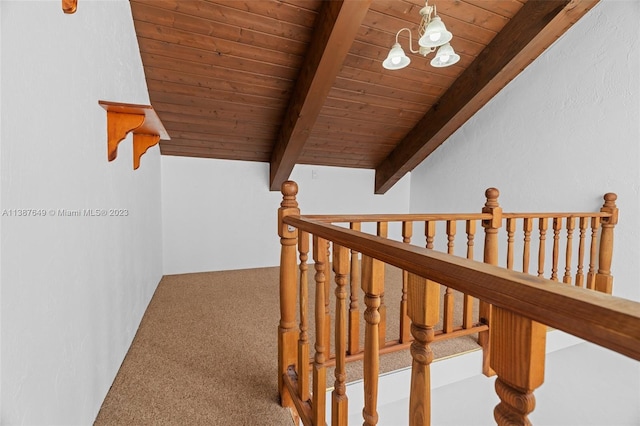 stairway featuring lofted ceiling with beams, wood ceiling, a notable chandelier, and carpet