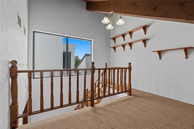 hall featuring carpet floors, vaulted ceiling, and an inviting chandelier