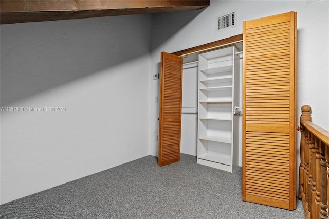 unfurnished bedroom featuring a closet and dark carpet