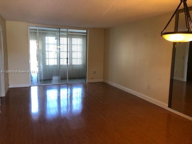 unfurnished room with dark wood-type flooring