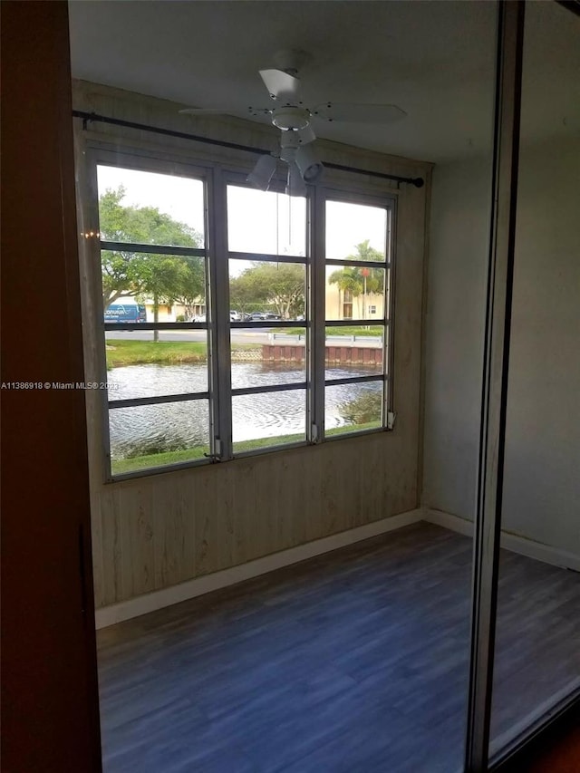 spare room with dark wood-type flooring, ceiling fan, and a wealth of natural light