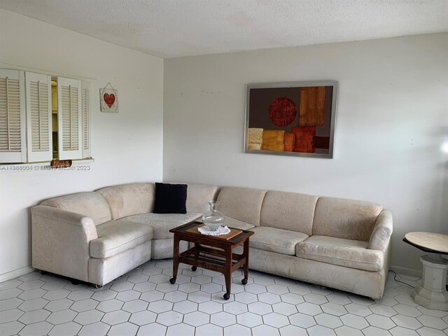 living room featuring a textured ceiling and light tile flooring