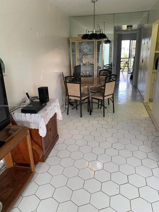 dining area with light tile floors and an inviting chandelier