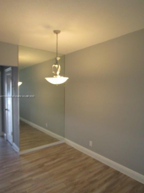 empty room with dark hardwood / wood-style flooring