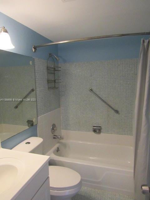 full bathroom featuring vanity, shower / bath combo with shower curtain, and toilet