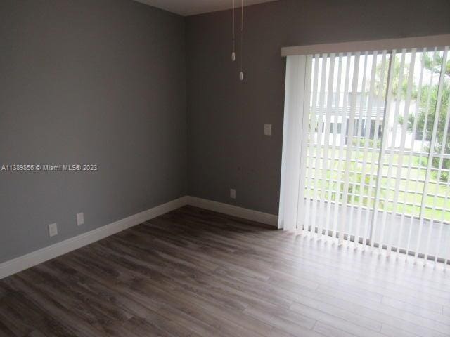 unfurnished room with dark wood-type flooring