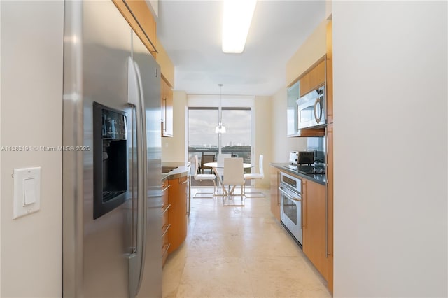 kitchen featuring decorative light fixtures, appliances with stainless steel finishes, and floor to ceiling windows