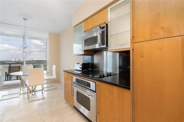 kitchen with expansive windows, appliances with stainless steel finishes, and pendant lighting