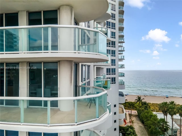 balcony featuring a beach view and a water view