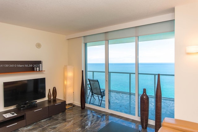 living room with a water view and a textured ceiling