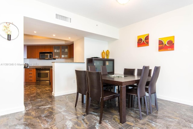 tiled dining space featuring vaulted ceiling