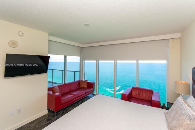 bedroom with a water view and a textured ceiling