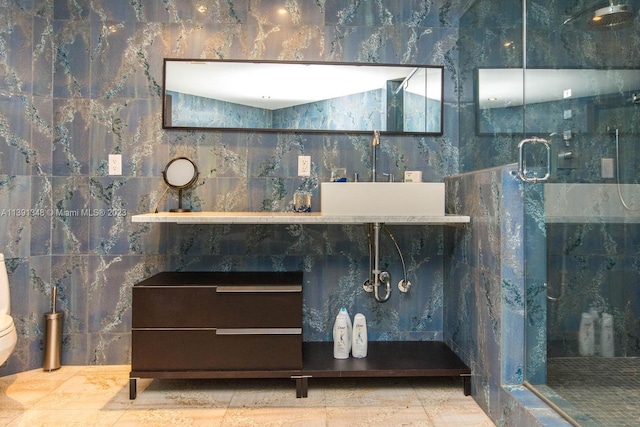 room details featuring light tile floors, vanity, and a shower with door