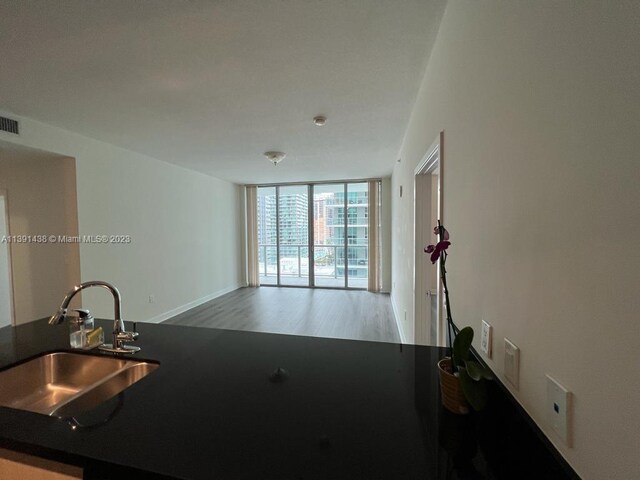 unfurnished room with hardwood / wood-style floors and a wall of windows