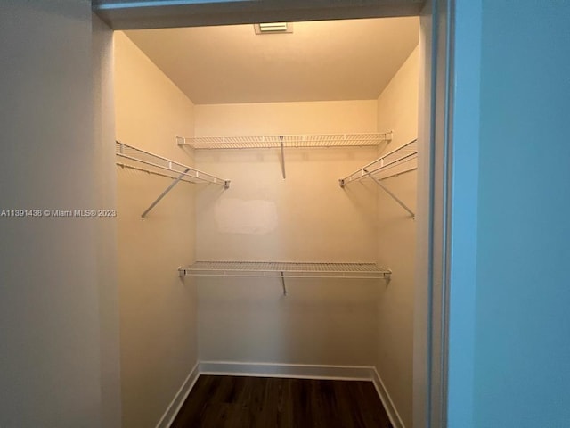 bathroom featuring a shower with shower door, toilet, and vanity with extensive cabinet space