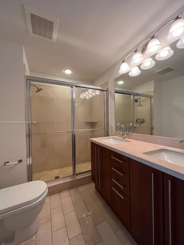 bathroom with a shower with door, toilet, tile flooring, and double sink vanity