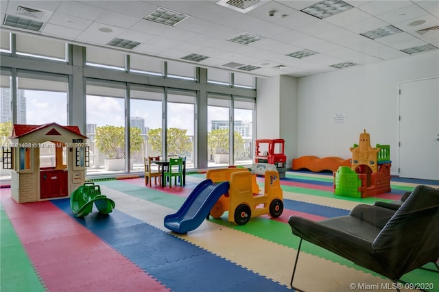 recreation room featuring a wealth of natural light and a paneled ceiling