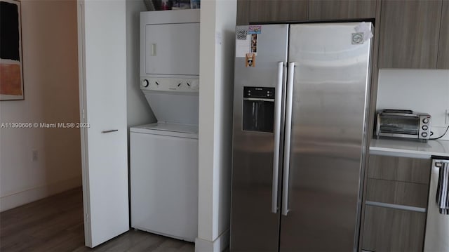 kitchen with high quality fridge, dark hardwood / wood-style flooring, and stacked washing maching and dryer