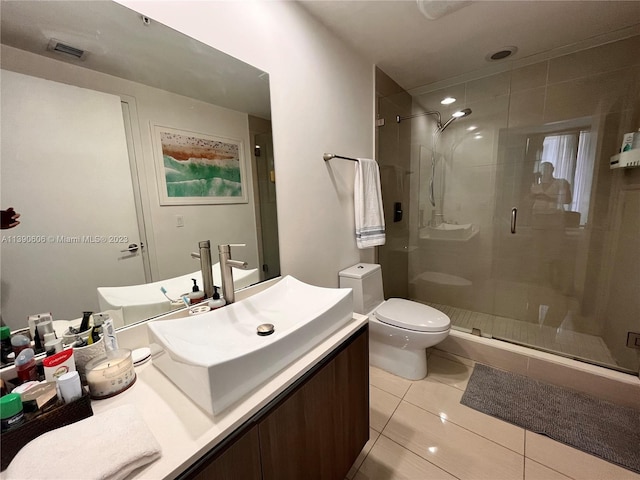 bathroom with walk in shower, toilet, vanity with extensive cabinet space, and tile flooring