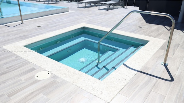 view of swimming pool featuring an in ground hot tub and a patio