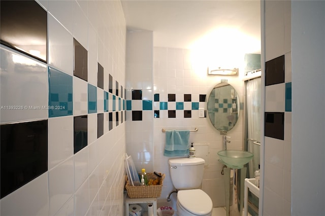 bathroom with tile walls and toilet