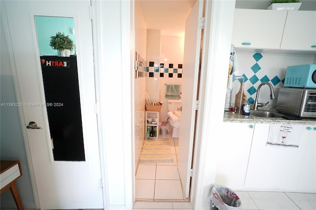 hallway featuring sink and light tile floors